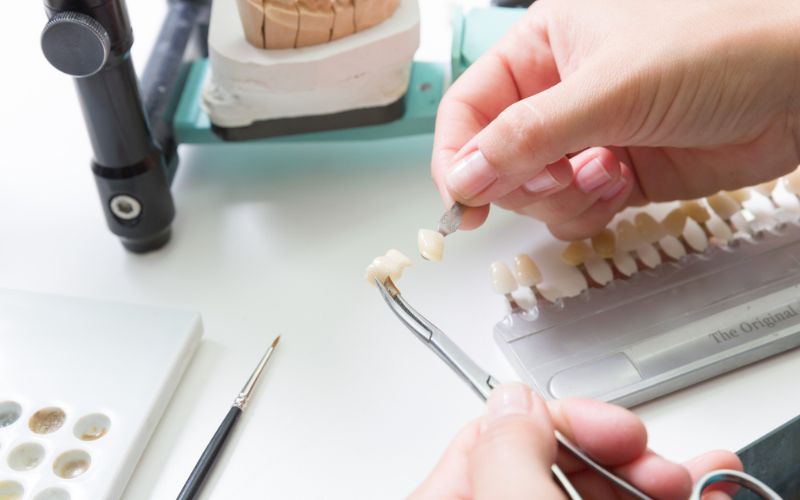 A person is working on a model of a tooth for teeth whitening research.