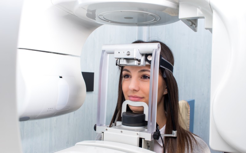 A woman is looking at an mri machine.