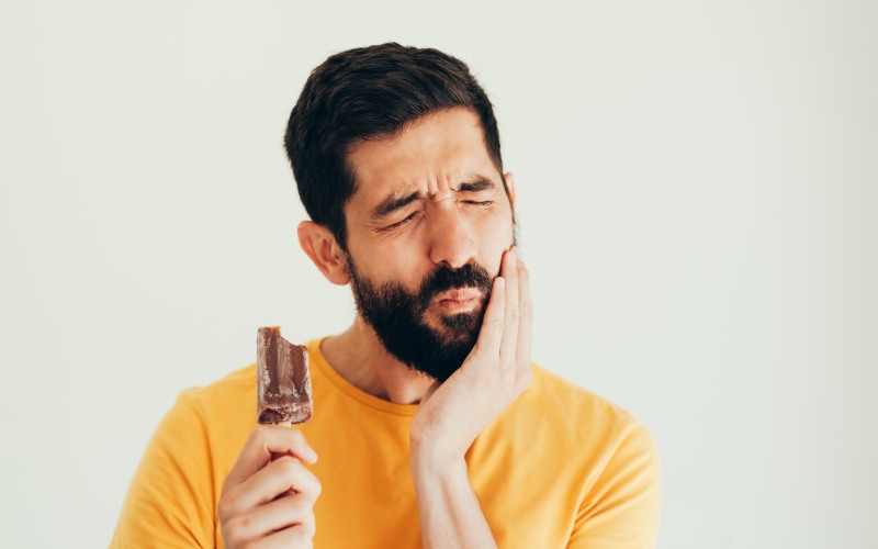 A man with a beard is holding an ice cream.